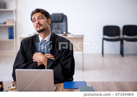 Young male judge taking oath on holly bible 97384964