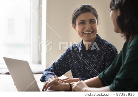 Happy young Indian employee woman talking to colleague 97385936