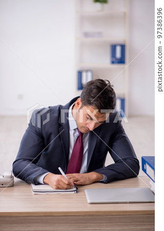 Young male employee working in the office Young male employee working in the office 97386396