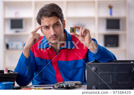 Young male repairman repairing computer 97386420