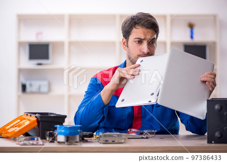 Young male repairman repairing computer Young male repairman repairing computer 97386433