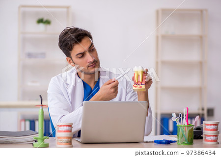 Young male dentist working in the clinic Young male dentist working in the clinic 97386434