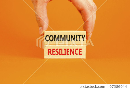 Community resilience symbol. Concept word Community resilience typed on wooden blocks. Beautiful orange table orange background. Businessman hand. Business and community resilience concept. Copy space 97386944