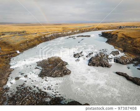 Bright blue river trough Iceland mainland in autumn time on a cold cloudy day 97387408