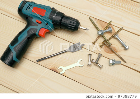 set of tools on wooden table, a electric screwdriver with a set of drill bits and screws with bolts. work tool on wooden background. Hand tool closeup set of tools on wooden table, a electric screwdriver with a set of drill bits and screws with bolts. work tool on wooden background. Hand tool closeup 97388779
