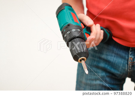 Hand holding cordless drill. Handyman with a tool screwdriwer drill. 97388820