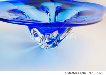 a large beautiful dish made of blue glass on a white background. a large beautiful dish made of blue glass on a white background. 97392420