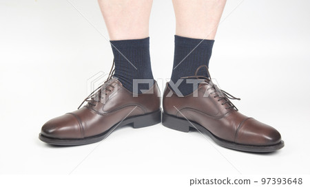 Male legs in socks and brown classic shoes on a white background 97393648