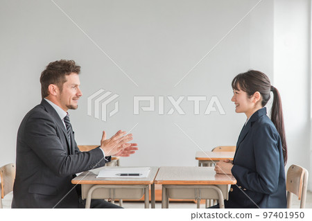A teacher and a smiling Asian high school student who conducts career counseling, two-way interviews, and interview practice at school about the school of choice 97401950