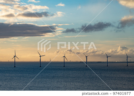 Wind farm in the open sea during sunset. Offshore wind generators. Renewable and green energy concept. Wind farm in the open sea during sunset. Offshore wind generators. Renewable and green energy concept. 97401977