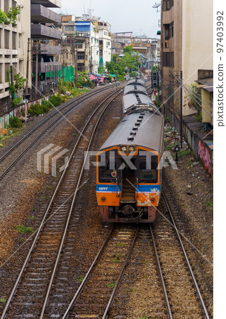 Diesel train of the State Railway of Thailand running through downtown Bangkok 97403992