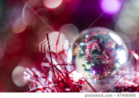 Close-up of Christmas decorations on a tree through lensball sphere Close-up of Christmas decorations on a tree through lensball sphere 97406998
