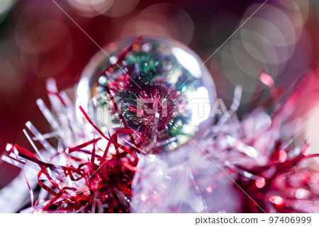 Close-up of Christmas decorations on a tree through lensball sphere 97406999
