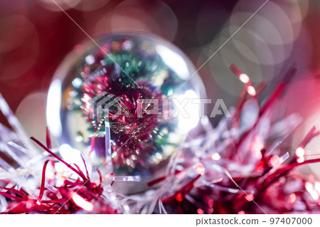 Close-up of Christmas decorations on a tree through lensball sphere Close-up of Christmas decorations on a tree through lensball sphere 97407000