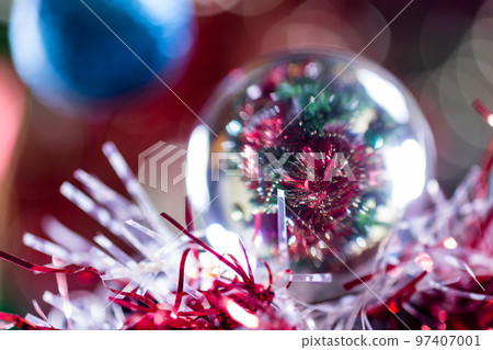 Close-up of Christmas decorations on a tree through lensball sphere Close-up of Christmas decorations on a tree through lensball sphere 97407001