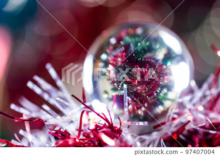 Close-up of Christmas decorations on a tree through lensball sphere Close-up of Christmas decorations on a tree through lensball sphere 97407004