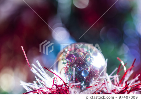Close-up of Christmas decorations on a tree through lensball sphere Close-up of Christmas decorations on a tree through lensball sphere 97407009