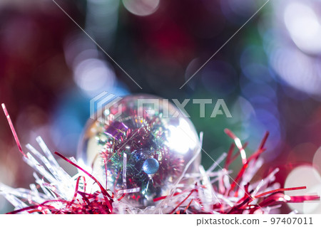 Close-up of Christmas decorations on a tree through lensball sphere Close-up of Christmas decorations on a tree through lensball sphere 97407011