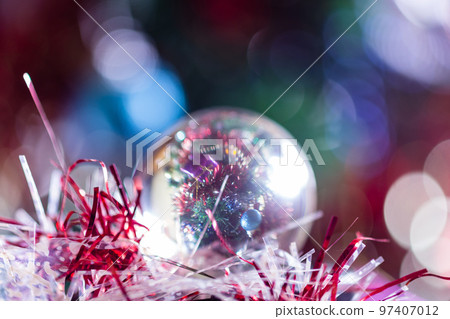 Close-up of Christmas decorations on a tree through lensball sphere Close-up of Christmas decorations on a tree through lensball sphere 97407012