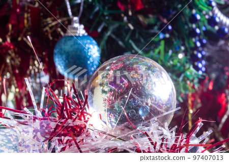 Close-up of Christmas decorations on a tree through lensball sphere 97407013