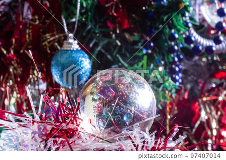 Close-up of Christmas decorations on a tree through lensball sphere Close-up of Christmas decorations on a tree through lensball sphere 97407014
