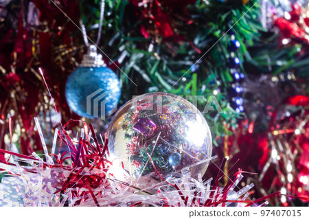 Close-up of Christmas decorations on a tree through lensball sphere Close-up of Christmas decorations on a tree through lensball sphere 97407015