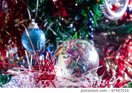 Close-up of Christmas decorations on a tree through lensball sphere Close-up of Christmas decorations on a tree through lensball sphere 97407016