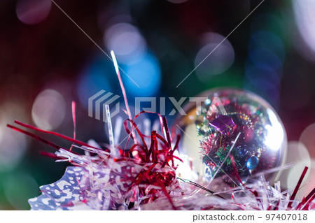 Close-up of Christmas decorations on a tree through lensball sphere Close-up of Christmas decorations on a tree through lensball sphere 97407018