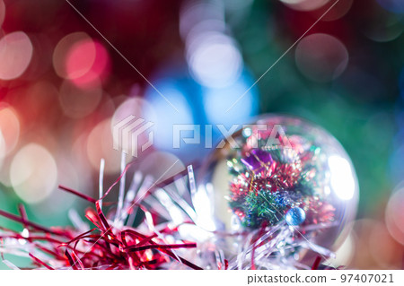 Close-up of Christmas decorations on a tree through lensball sphere Close-up of Christmas decorations on a tree through lensball sphere 97407021
