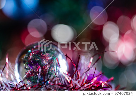 Close-up of Christmas decorations on a tree through lensball sphere Close-up of Christmas decorations on a tree through lensball sphere 97407024