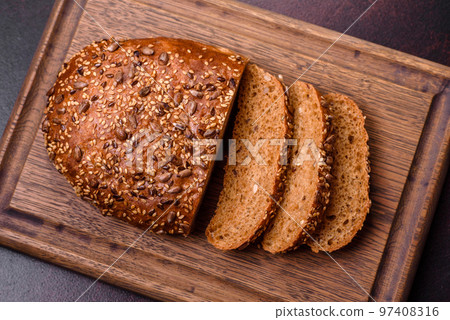 Delicious crispy bread with cereals on a wooden cutting board Delicious crispy bread with cereals on a wooden cutting board 97408316