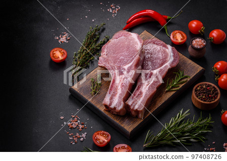 Fresh raw pork meat on the ribs with spices and herbs on a wooden cutting board 97408726