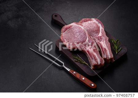 Fresh raw pork meat on the ribs with spices and herbs on a wooden cutting board 97408757