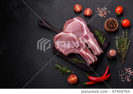 Fresh raw pork meat on the ribs with spices and herbs on a wooden cutting board 97408764