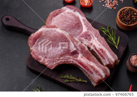 Fresh raw pork meat on the ribs with spices and herbs on a wooden cutting board 97408765