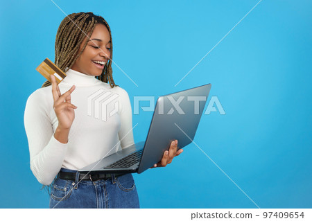 Studio portrait with blue background of a woman buying online. 97409654
