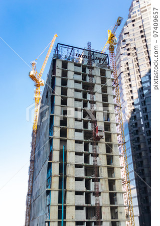 Construction crane is building a high-rise building. construction elevator is carrying people to work. Construction crane is building a high-rise building. construction elevator is carrying people to work. 97409657