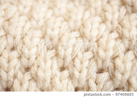closeup beige knitted woolen fabric texture background closeup beige knitted woolen fabric texture background 97409885