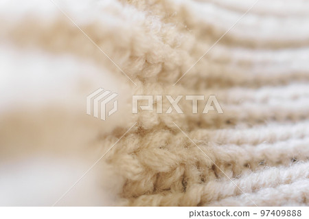 closeup beige knitted woolen fabric texture background 97409888