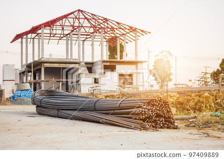 steel rebar for reinforcement concrete at construction site with house under construction background 97409889