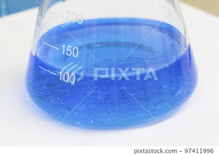 Blue liquid in a flask with sediment 97411996