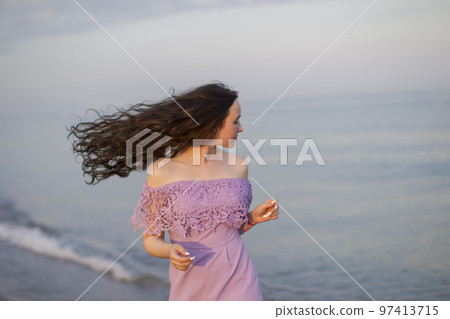Beautiful young girl on the background of the sea with long flowing hair 97413715