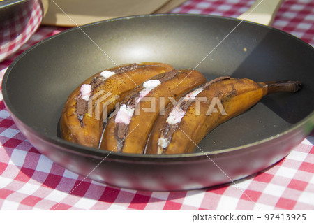 Fried bananas in a skillet. Unusual fruit dishes 97413925