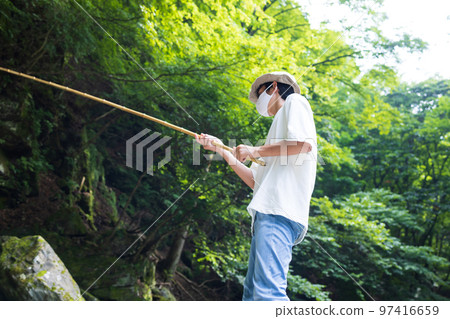 孩子們在溪流中享受釣魚 97416659