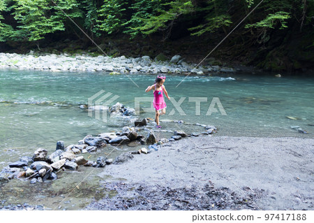 Toddler enjoying playing in the river Toddler enjoying playing in the river 97417188