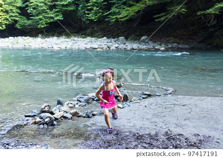 Toddler enjoying playing in the river Toddler enjoying playing in the river 97417191