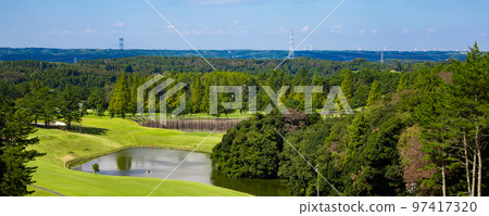 A panoramic view of a golf course with a blue sky, a difficult downhill course with ponds and numerous bumps (Kisarazu City, Chiba Prefecture) 97417320