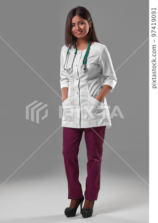 Beautiful young doctor in a medical robe with a stethoscope Beautiful young doctor in a medical robe with a stethoscope 97419091