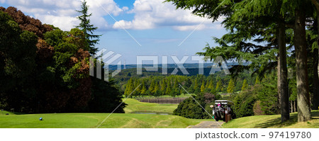 A view of a golf course with a blue sky, a difficult course downhill from a hill with a pond, and a panorama of a cart (Kisarazu City, Chiba Prefecture) 97419780