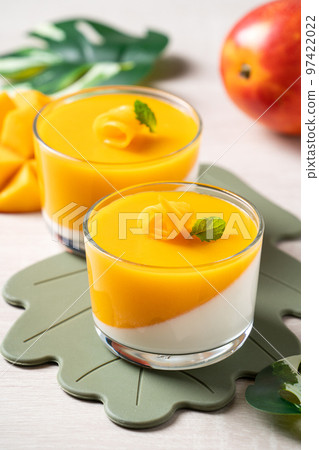 Delicious double colored mango panna cotta mousse pudding on wooden table background. 97422022